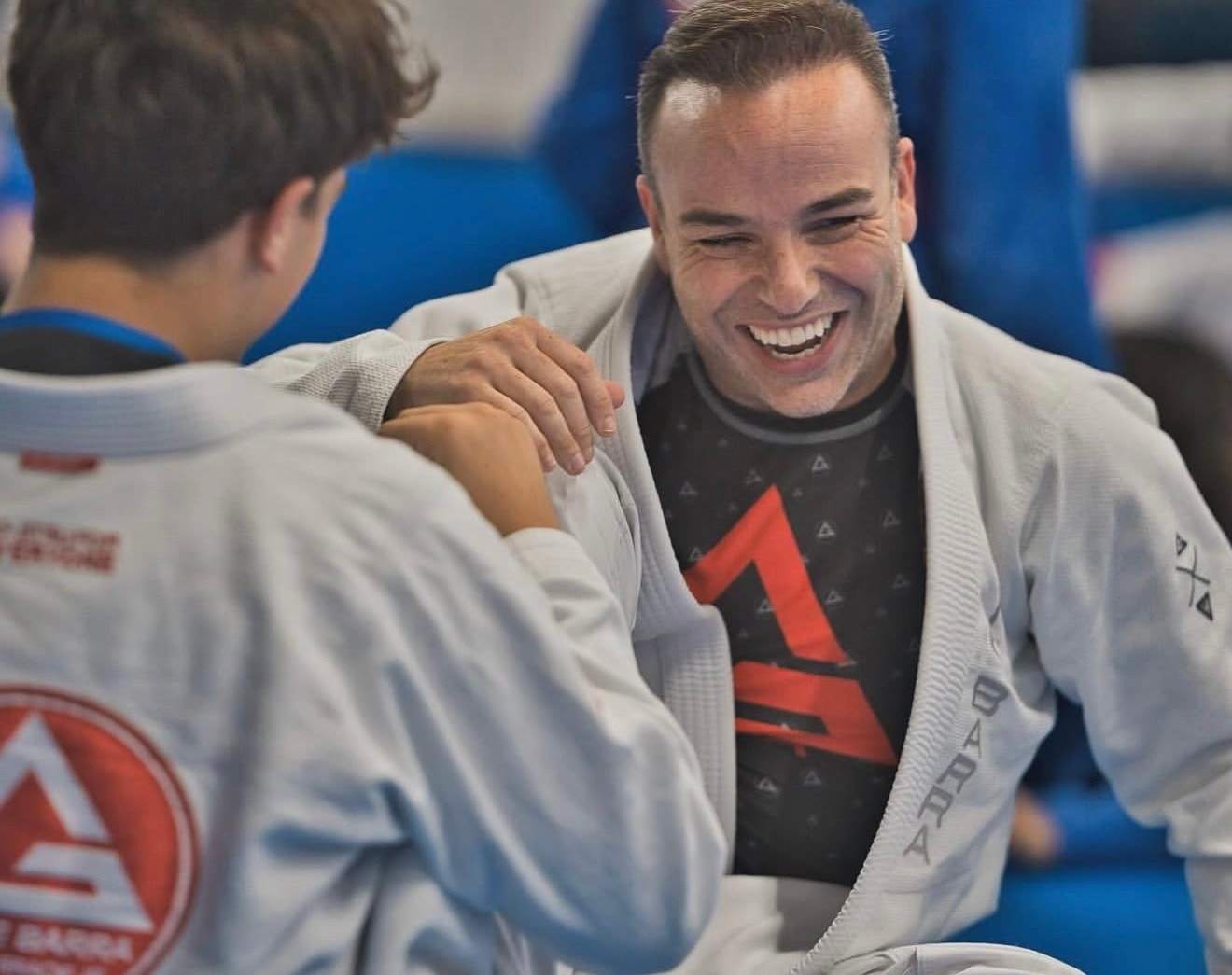 An adult student laughs while training with a teenage partner